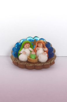 pesebre en miniatura artesanal con fondo azul y figuras de la Sagrada Familia en cerámica