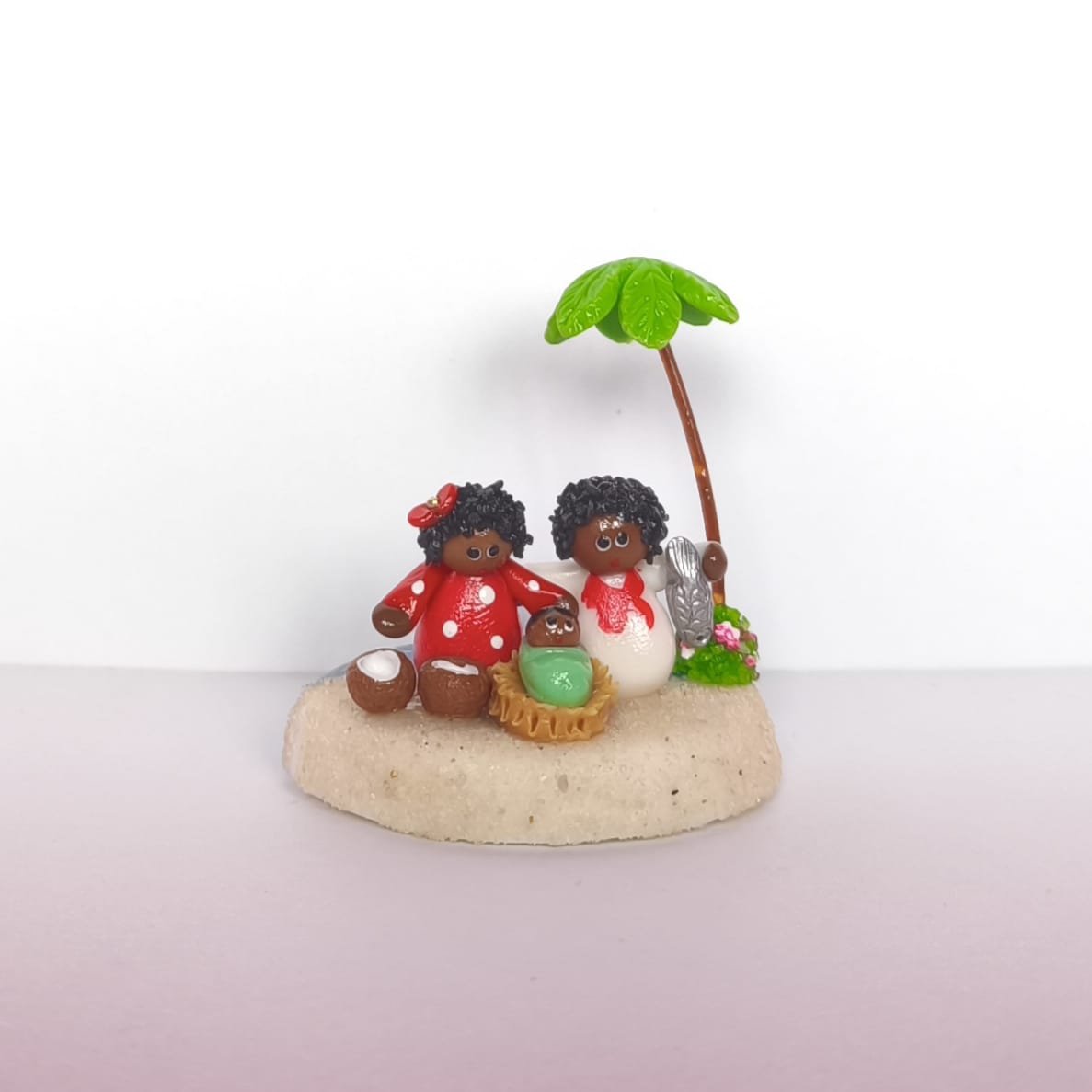 pesebre en miniatura artesanal , que muestra la Sagrada Familia en la playa rodeada de palmeras, peces y cocos.