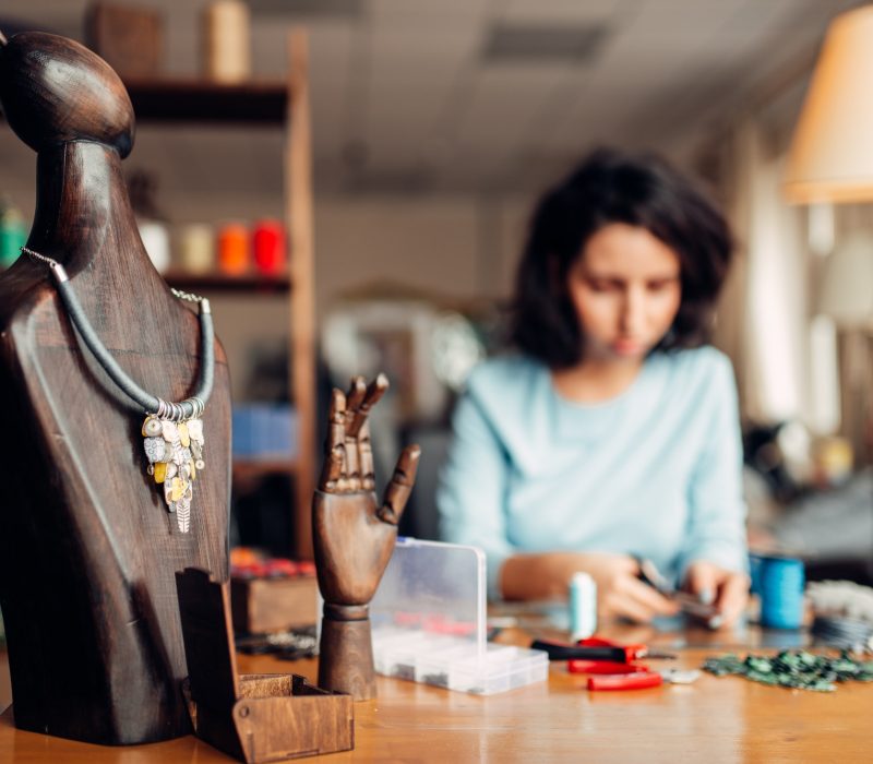 Handmade necklace on wooden mannequin, needlework